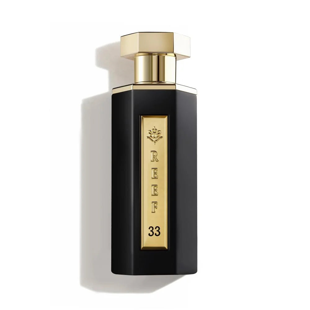 Perfume bottle with gold cap and 'REEF 33' branding on a white background